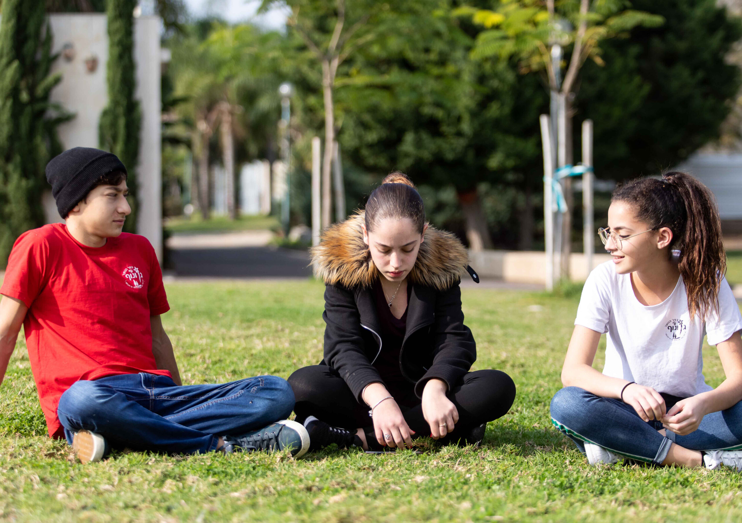 Tre ungdomar på en gräsmatta
